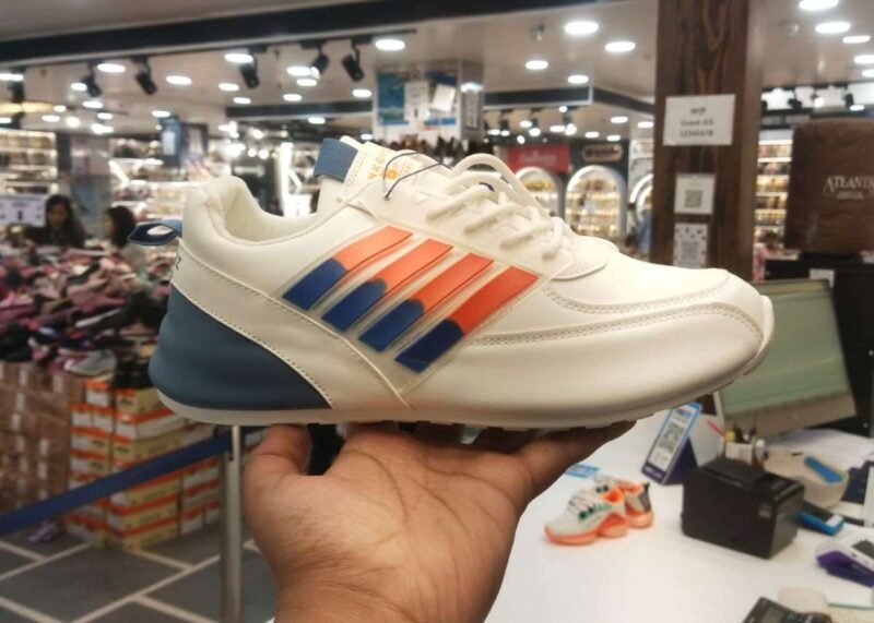 athletic shoe with blue and orange strips accents displayed in a store, ideal for morning walks and running.