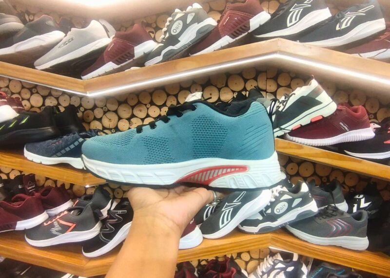 teal-colored running shoe with a white cushioned sole and black laces