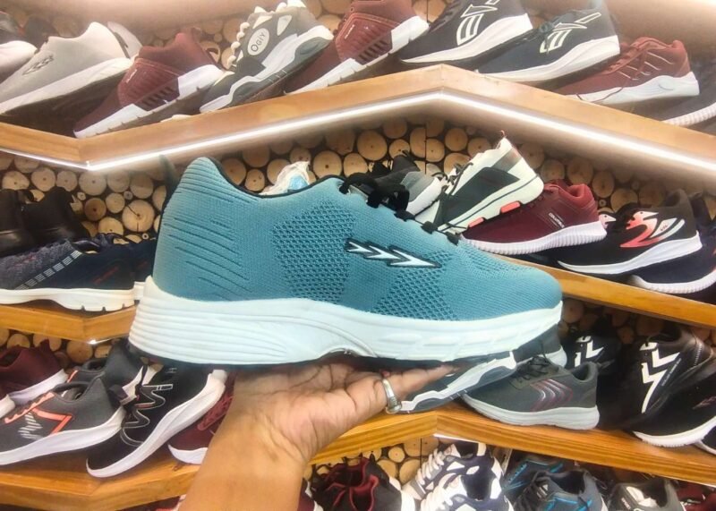 teal-colored running shoe with a white cushioned sole and black laces.