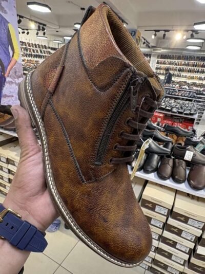Tiger Hill leather bootswith brown accents featuring lace-up and zipper designs, displayed on a tile floor at jain chappal store shahdara with branded packaging in the background.